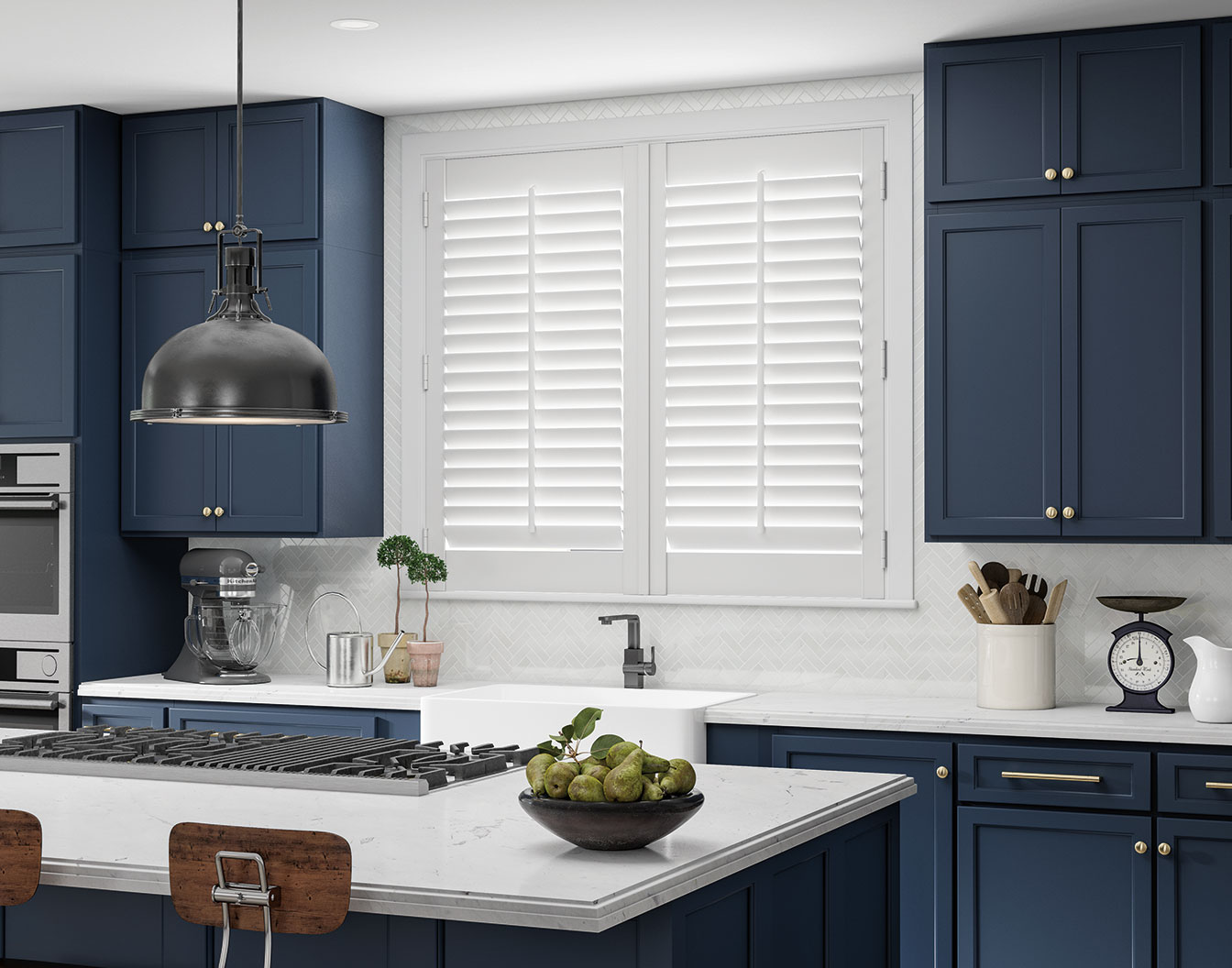 Modern kitchen with dark blue cabinets, white countertops, stainless steel appliances, and a bowl of green apples on the island, complemented by elegant window treatments.